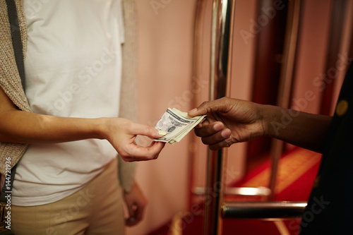 Hotel guest giving porter money for carrying her baggage