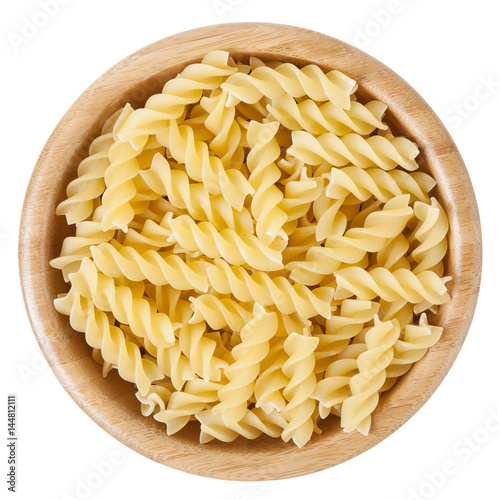 Fusilli pasta in wooden bowl isolated on white background with clipping path