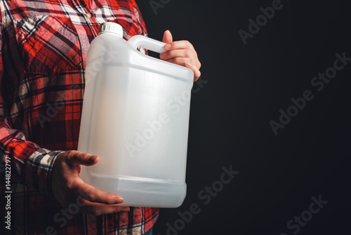 White plastic tank canister in female hand