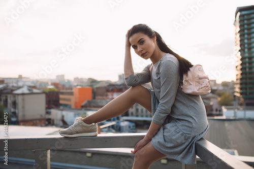 Stylish woman sitting on roof and relaxing