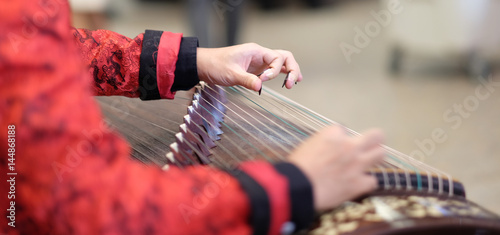 hand of man playing Guzheng.The guzheng or gu zheng, also simply called zheng, is a Chinese instrument