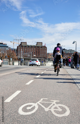 Rowerzysta z dzieckiem jadący po drodze rowerowej. Szwecja, Stockholm.