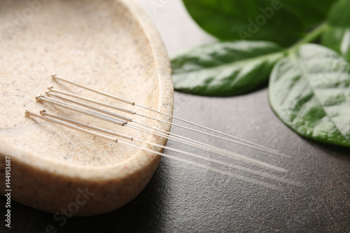 Special stand with needles for acupuncture on dark background, closeup