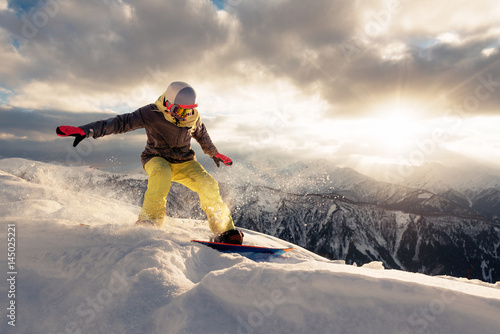 snowboarder is riding on the sunset