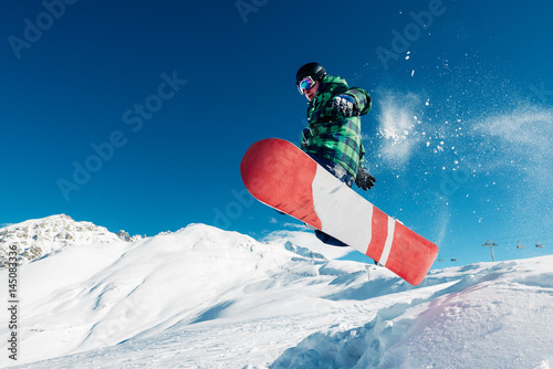 snowboarder is jumping with snowboard from snowhill