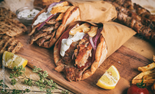 Greek gyros wrapped in pita breads on a wooden table