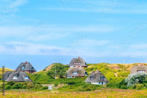 Typical Frisian houses with straw roofs on sand dunes in Kampen village, Sylt island, Germany