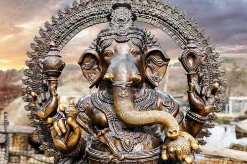Statue of Hindu Elephant God Ganesha outdoors against dramatic sky