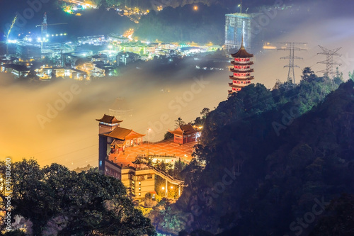 Chin Swee Cave Temple in Genting Highlands at dusk overlooking from viewpoint of Theme park hotel in the background