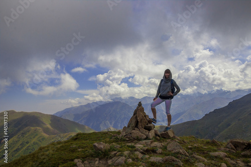 Young woman are standing on top of a mountain and enjoying. Almaty, peak named Furmanov