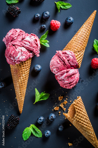 Sweet ice cream with berry fruits on blackboard