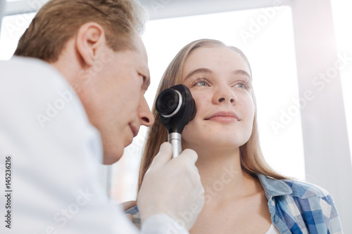 Attentive dermatologist exploring teenager skin in the hospital