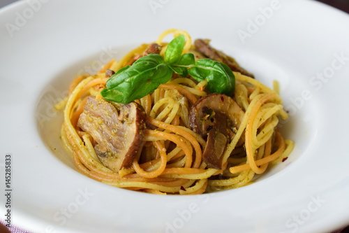 Pasta with mushroom.s and pesto sauce in a white plate on abstract bckground. Italian lifestyle. Healthy eating concept