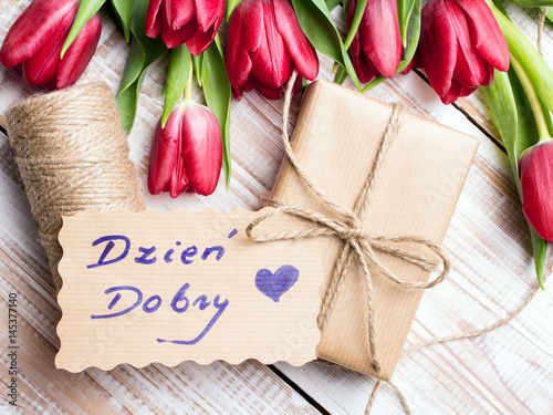 Polish words Good morning and bouquet of tulips on wooden background