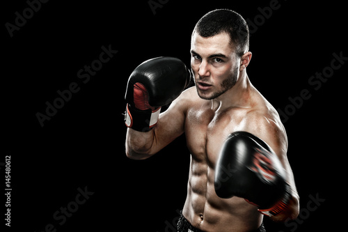 Sportsman Muay Thai boxer celebrating flawless victory in boxing cage. Isolated on black background with smoke. Copy Space.