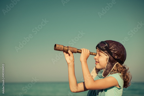 Happy kid playing outdoor against sea and sky