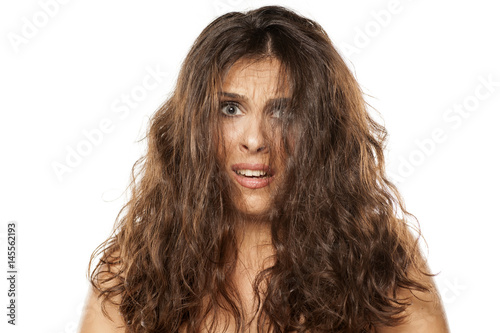 A young unhappy woman with a messy long hair