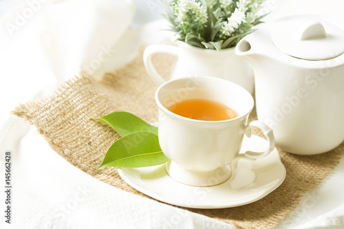 Close up organic tea in white cup with green leaf , Tea ceremony time concept