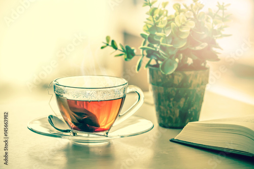 Zamyka w górę ciepłej czarnej herbacianej filiżanki na drewnianym stole w żywym pokoju, relaksuje z herbacianego czasu pojęciem