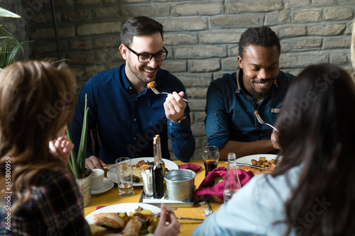 Group of happy business people eating in restaurant