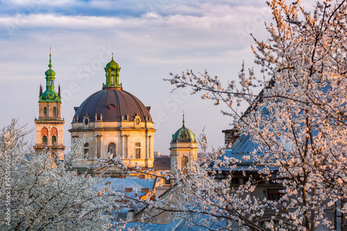 Lviv architecture. Dominican temple. Blossom trees in spring evening.