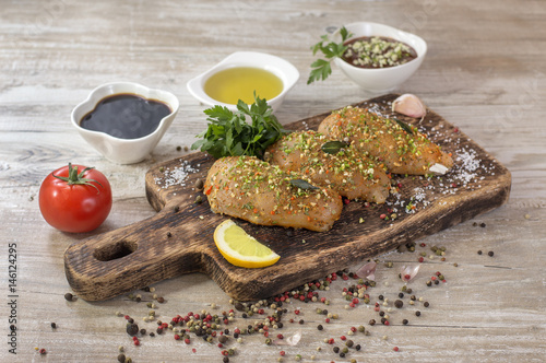 Chicken fillet in marinade on a wooden board. 