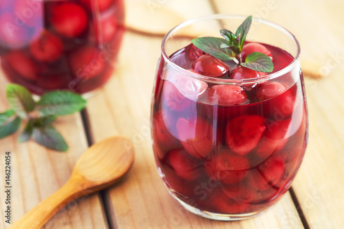 Sour cherry compote dessert served with mint leaves