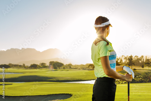Woman standing on golf course on a sunny day