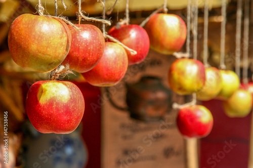 dojrzałe jabłka wiszące na sznurku na straganie jako ozdoba