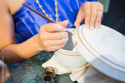 Tajlandzka kobieta używa muśnięcie malującego projekt na zbiornikach, ceramiczna tradyci sztuka Tajlandia