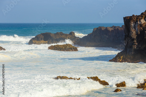 Los Hervideros, volcanic coastline with wavy ocean and blue sky, Lanzarote island, Spain