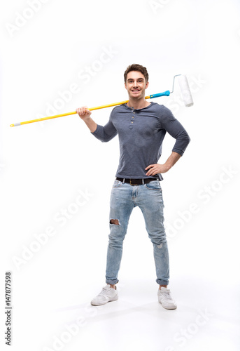 handsome man holding paint roller and isolated on white, handyman tools concept