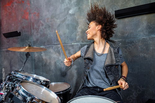 portrait of emotional woman playing drums in studio, drummer rock concept