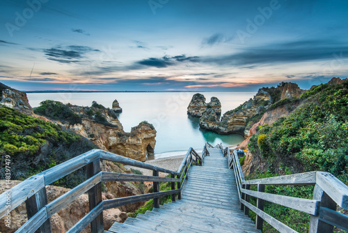 Wooden footbridge walkway to beautiful beach Praia do Camilo on coast of Algarve region, Portugal
