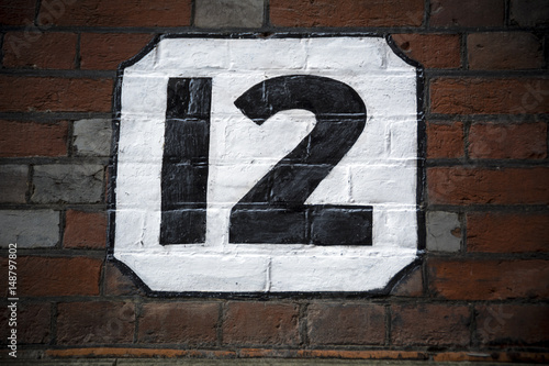 Number twelve hand painted on plaster background