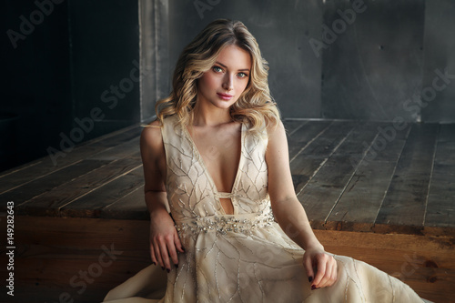 Fashion model in long dress on the metal background