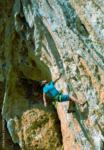 Rock Climber in dangerous position preparing the next move up
