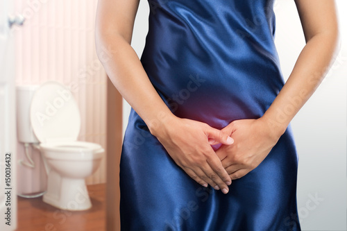 Woman with prostate problem in front of toilet bowl. Lady with hands holding her crotch, People wants to pee - urinary incontinence concept