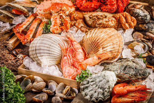 Seafood cuisine plate as an ocean gourmet dinner background. Crab, seashells, oysters, shrimp and other seafood delicacies.