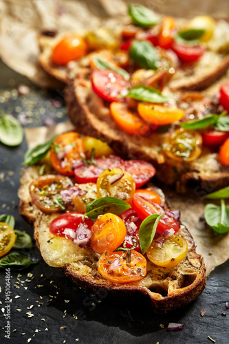 Tomato bruschetta with grilled homemade bread with cheese and fresh herbs