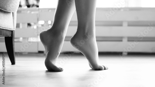 female soigne beautiful feet on tiptoe on floor