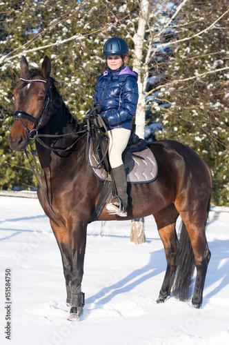 Ten years girl riding a horse in winter