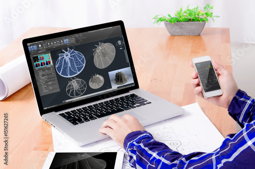 Cad engineer's workplace. Close up of engineer's hands working on the notebook and tablet.