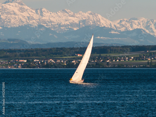 Sailing boat on a lake with Alps in background