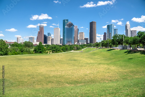Downtown Houston at daytime with cloud blue sky. Green park lawn and modern skylines. It is the most populous city in Texas and the fourth-most in United States. Architecture and travel background.