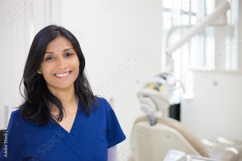 Closeup headshot portrait of friendly, cheerful, smiling confident female, healthcare professional in blue scrubs. isolated clinic hospital background. Patient visit.