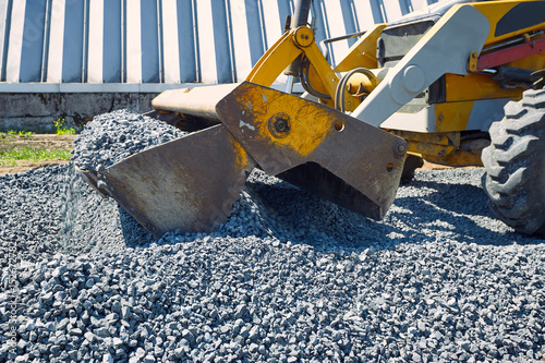 Laying rubble on the road with a heavy excavator.