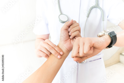 Nurse taking the patient's pulse hand on white background