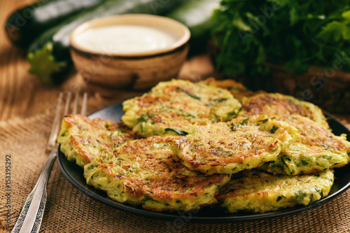 Vegetarian food - zucchini fritters on wooden background.