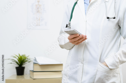 A female doctor texting on smartphone
